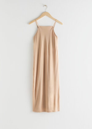 Knälång midiklänning. Klänningen är beige och modemedveten.