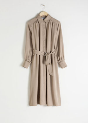 Knälång midiklänning med knappar. Klänningen är beige och sexig.