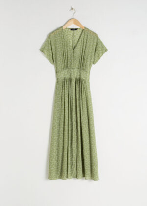 Flirtig green klänning med knappar med knappar.